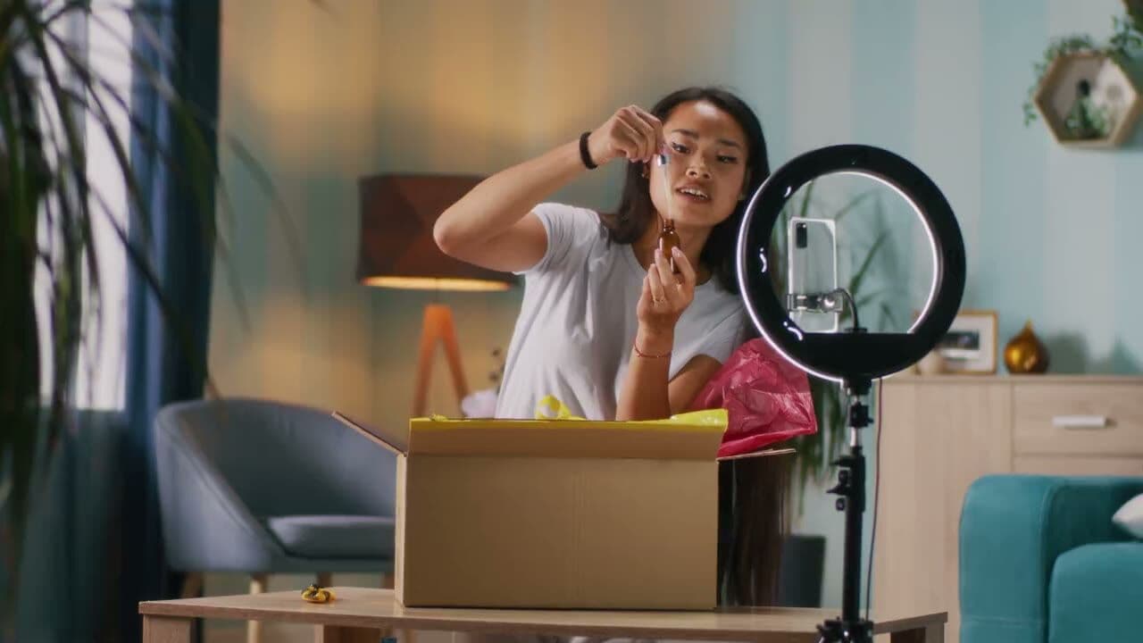 A creator's hands working with product and a phone on a tripod
